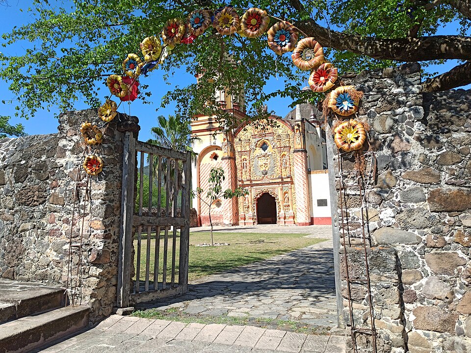 Misión de Concá vista a través de un arco decorado con flores